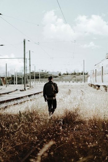 man walking into grass field during daytime