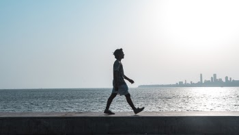 Man Walking Near Body of Water