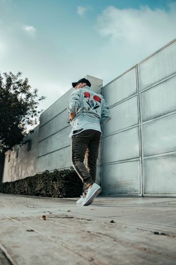 man walking near gray concrete wall at daytime