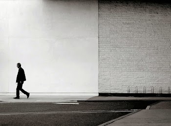 Man Walking Near Wall and Road