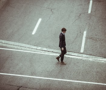 man walking on asphalt road