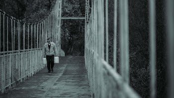 Man Walking on Bridge