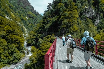 Man Walking on Gray and Red Bridge