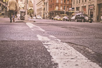 Man Walking on Grey Asphalt Road