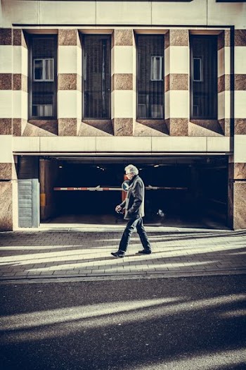 man walking on pavement in front of concrete structure