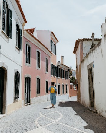 Man Walking on Road Near Buildings