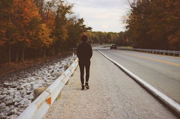 man walking on roadside