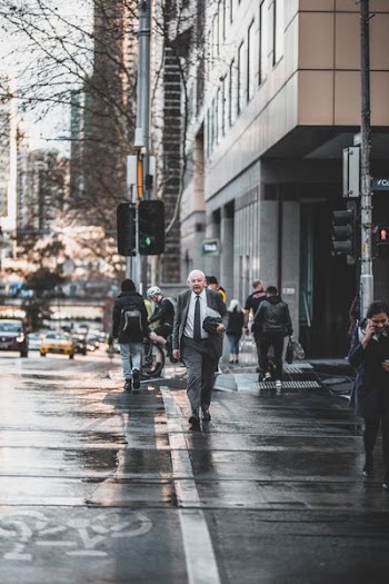 man walking on wet road near building at daytime