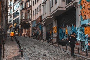 Man Walking Outside the Building White Talking on Phone