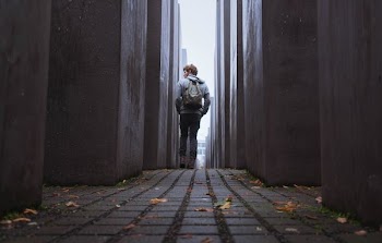 man walking through gray walls