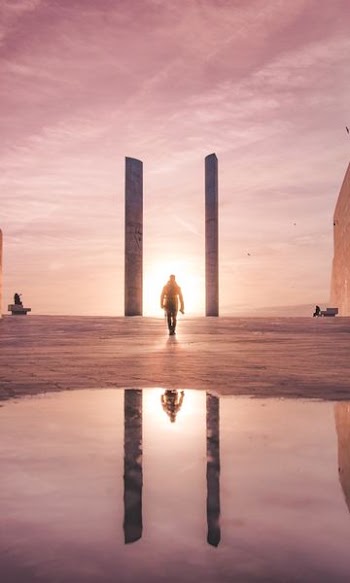 man walking towards the sun