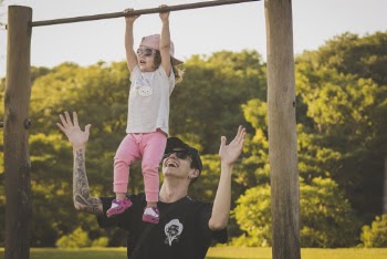 Man Watching Girl on Monkey Bar