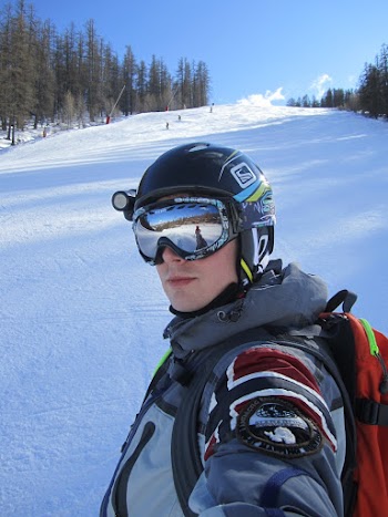 Man Wearing A Jacket And Goggles Standing On Snowy Field
