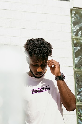 Man Wearing A White T-shirt And A Watch Looking Downwards