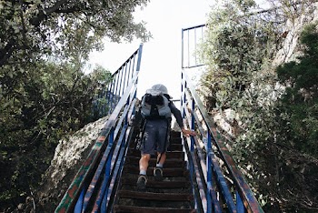 Man Wearing Backpack Going Upstairs