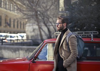 Man Wearing Beige Jacket Beside Red Car
