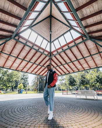 Man Wearing Black and Red Jacket Standing Under  A Framed Canopy