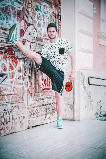 Man Wearing Black and White Crew-neck T-shirt With Right Foot Up