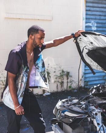 Man Wearing Black and White Polo Shirt Looking at Honda Engine Bay