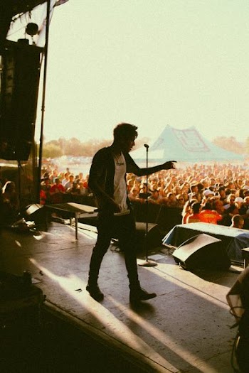 man wearing black and white shirt on stage at daytime