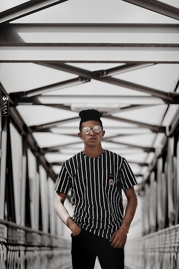 Man Wearing Black and White T-shirt Standing on Bridge