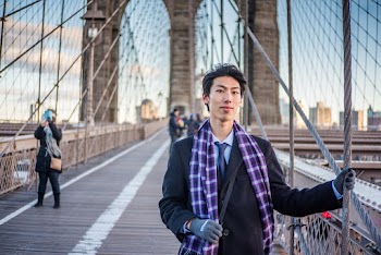 Man Wearing Black Coat and Purple Checked Scarf Holding on Gray Steel Rope