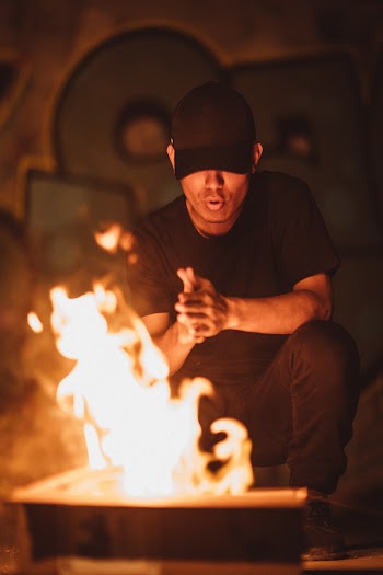 Man Wearing Black Crew-neck Shirt and Black Jeans in Front of Flame