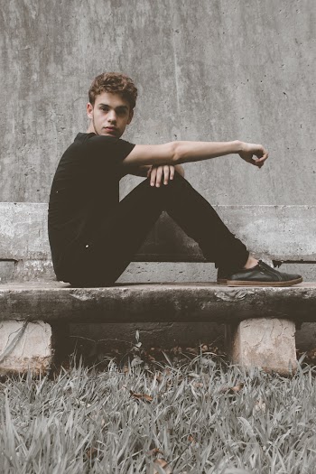 Man Wearing Black Crew-neck Sitting on Bench