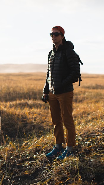 Man Wearing Black Hooded Jacket Standing on Brown Grass