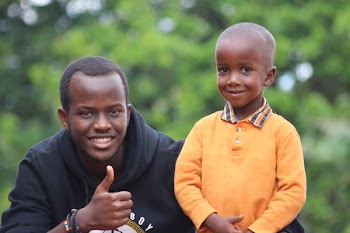 Man Wearing Black Hoodie Beside Boy Wearing Orange Long-sleeved Polo Shirt