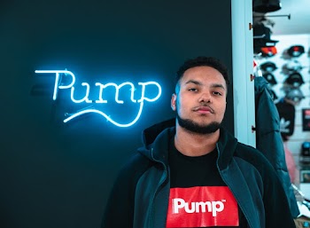 Man Wearing Black Jacket and Pump Shirt Standing Near A Wall