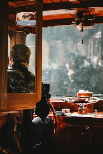 Man Wearing Black Jacket Driving Brown Bus