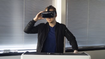 Man Wearing Black Jacket Holding Vr Inside the Room