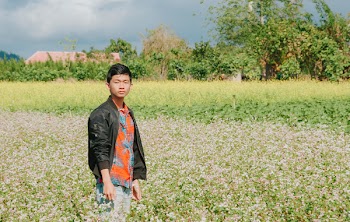 Man Wearing Black Jacket Surrounded By Plants