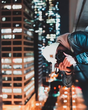 Man Wearing Black Leather Jacket Holding Camera