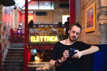Man Wearing Black Scoop-neck Shirt Holding Black Canon Dslr Camera