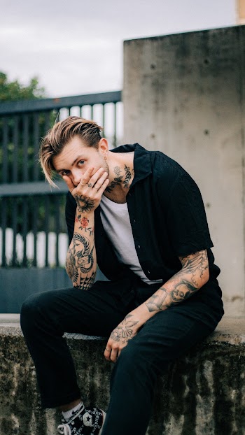 Man Wearing Black Shirt and Black Pants Sitting Down