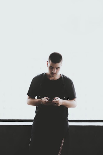 Man Wearing Black Shirt Holding Smartphone