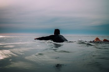 man wearing black shirt on body of water