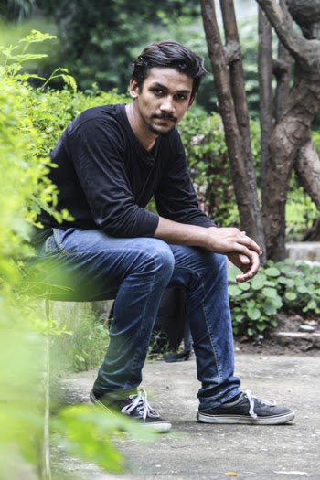 Man Wearing Black Shirt Sitting Near the Plant