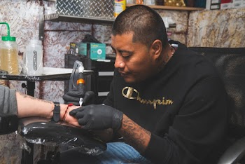 Man Wearing Black Shirt Tattooing A Person