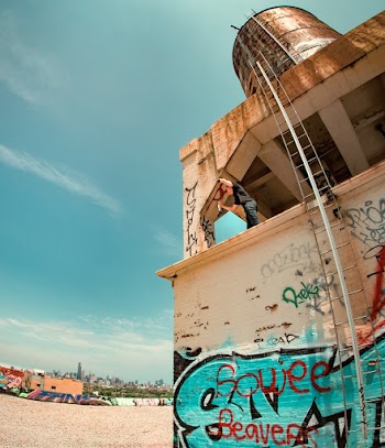 Man Wearing Black Shirt With Blue Denim Jeans on Building