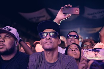 Man Wearing Black Sunglasses Sitting Next to Man