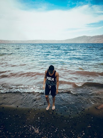 Man Wearing Black Tank Top Standing On Shore