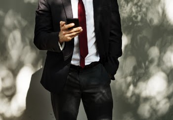 Man Wearing Black Tuxedo Holding Black Smartphone