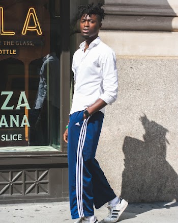 Man Wearing Blue and White Adidas Track Pants With Hands on Pocket