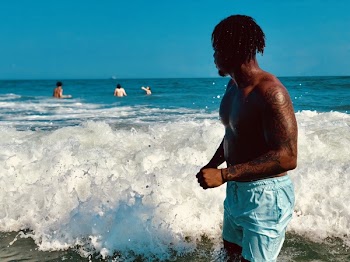 Man Wearing Blue Boardshorts Near Waves