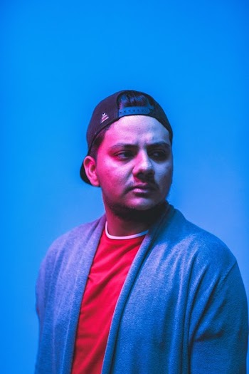 Man Wearing Blue Cardigan and Black Trucker Cap