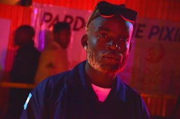 Man Wearing Blue Collared Shirt and Earring Inside Red-lighted Room