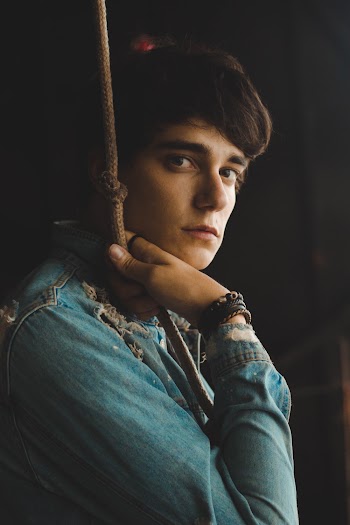 Man Wearing Blue Denim Jacket Holding Brown Rope Close-up Photo